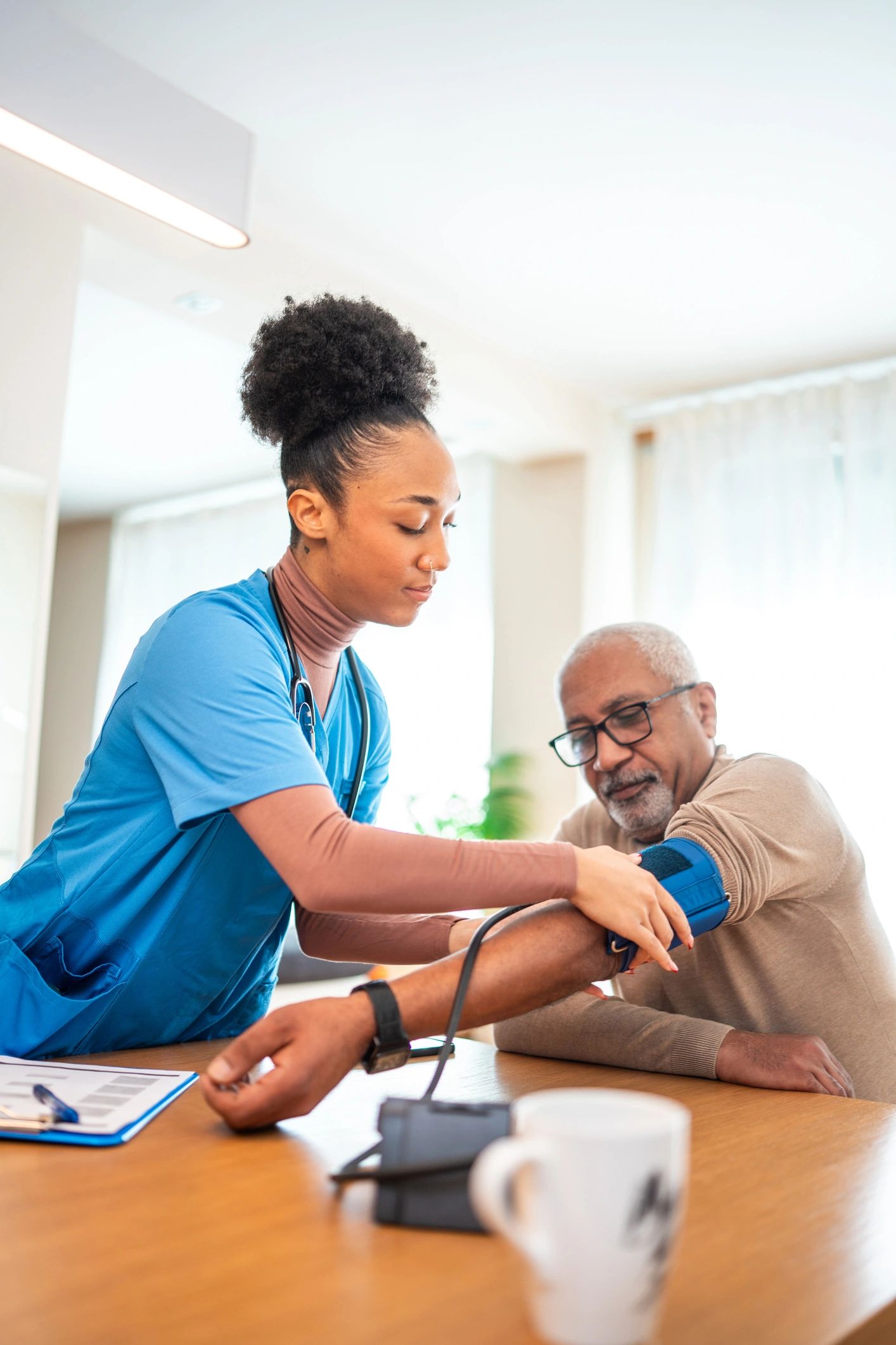 Healthcare professional supporting a senior man at home